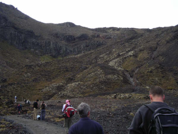 Sur la montagne, au loin, une ligne de personnes escaladant la falaise