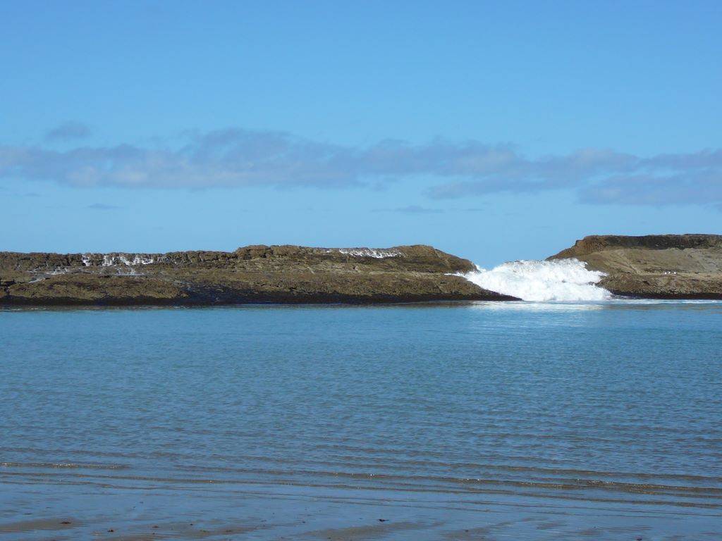 La barrière est harcelée par les vagues qui parfois arrivent à la dépasser et se déversent dans le bassin.