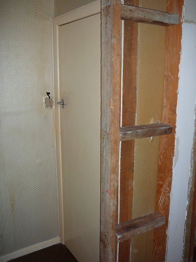 Derrière Seb, la porte, restée là, vers ce qui était avant un toilette. Mainteant, derrière cette porte, il y a la douche de la salle de bain.