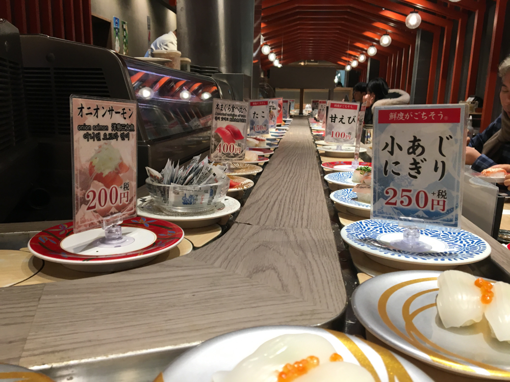 Restaurant avec un train à sushi pour finir la journée.