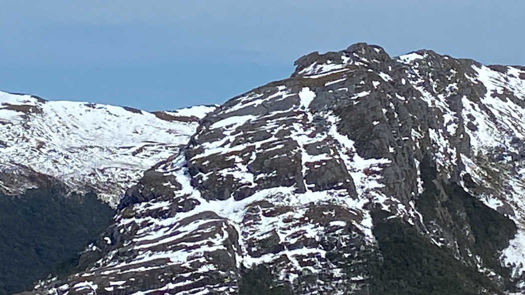 En face, au sommet du Mont Xenicus, une forme se détache, faisant penser à un ours géant qui surveillerait la vallée.