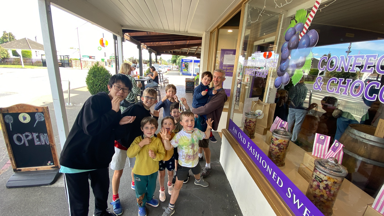 Ces huit enfants s'appretent a rentrer dans un magasin de bonbons!